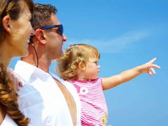 Family with a child pointing towards the horizon